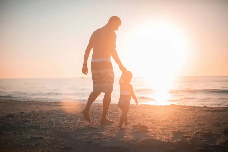 El Dr. García con su hijo pequeño en una playa al atardecer