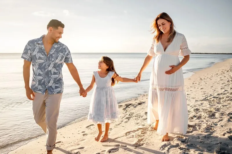Dr. García y su esposa e hija embarazadas en la playa.