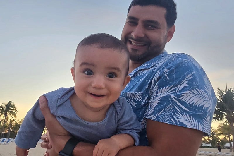 Dr. García sosteniendo a su hijo sonriente